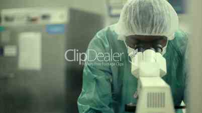 Man at work with microscope in biotechnology lab