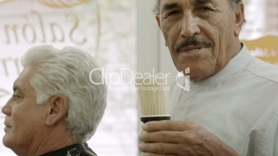 Portrait of senior man working as barber in hair salon