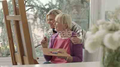 Women portrait with happy mom painting and daughter smiling