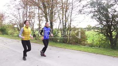 two woman jogging in autumn