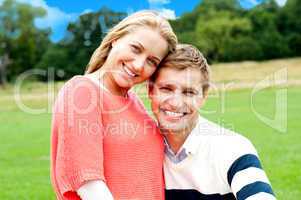Young couple outdoors sitting on green grass