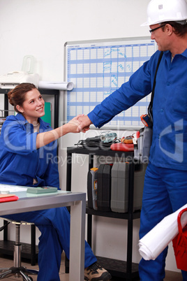 blue collar coworkers shaking hands