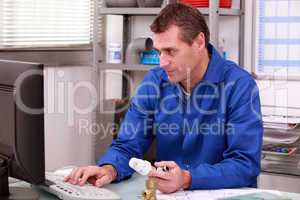 Plumber's merchant looking up the details for a thermostatic valve on the computer