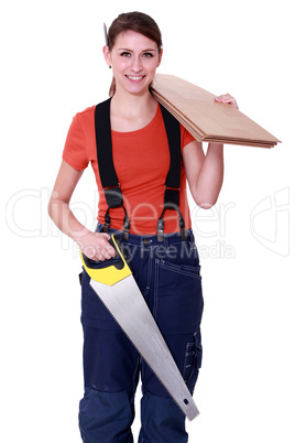 Woman carrying plywood and a saw