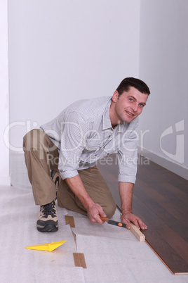 Man laying wooden flooring