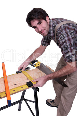 Carpenter measuring wood on a workbench