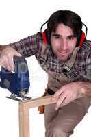 A carpenter using a tool