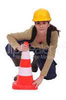 Labourer placing a traffic pylon
