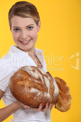 Woman holding round loaves of bread