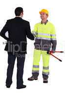 Architect and construction worker shaking hands