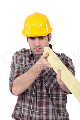 Builder with a plank of wood
