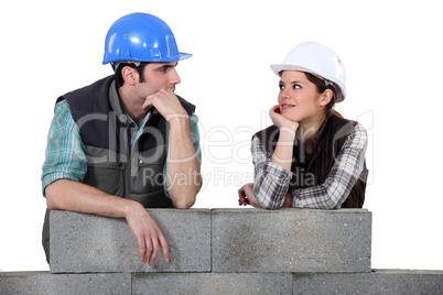 Builders leaning on an unfinished wall