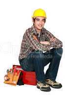 portrait of young craftsman sitting on toolcase