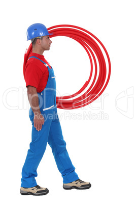 Plumber carrying pipes.