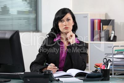 Brunette office worker thinking