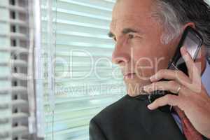 Man peering through some blinds