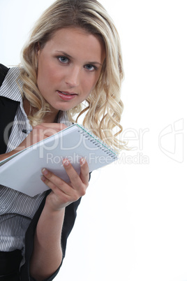 Blond office worker writing on note pad