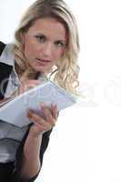 Blond office worker writing on note pad