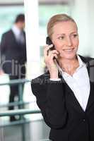 Smart business woman using a cell phone in an office environment