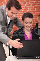 Young businesspeople looking at a laptop