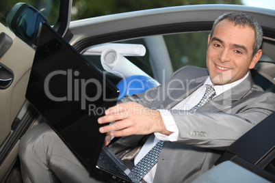 Architect sitting in his car with a laptop