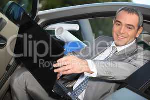 Architect sitting in his car with a laptop