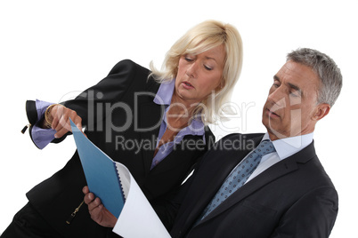 businessman and businesswoman reading a report