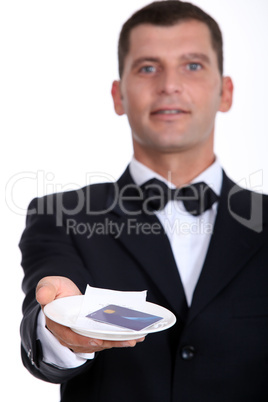 Male waiter holding credit-card and receipt