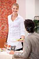 Waitress handing meal to customer