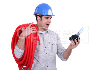 Electrician holding piggy-bank