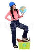 Young female builder holding globe