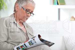 Elderly woman reading magazine