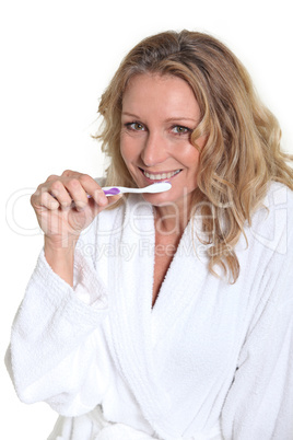 Woman holding toothbrush to mouth