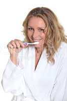 Woman holding toothbrush to mouth