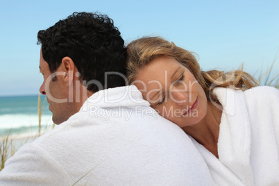 Couple by the sea in toweling robes