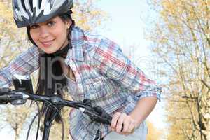 Young woman pushing a bicycle