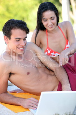 Couple in bathing suit with laptop