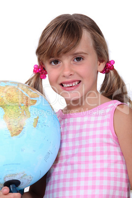 Young schoolgirl with a large globe