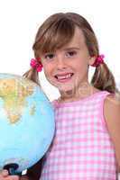 Young schoolgirl with a large globe
