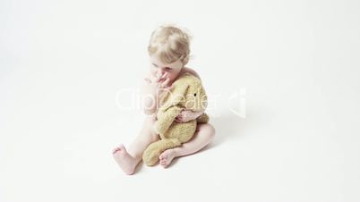 Blond Baby Girl Sitting With Her Toy Bunny