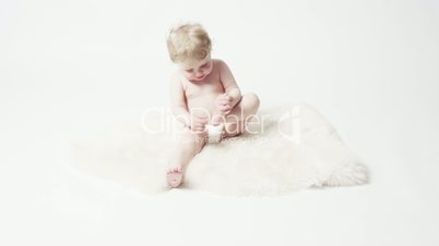 Baby Girl on White Rug Playing With Her Feet