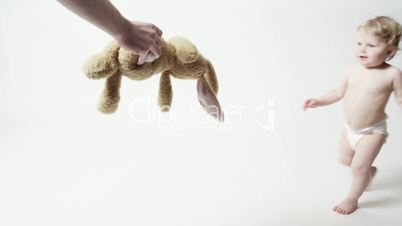 Blond Baby Girl Reaching for her Stuffed Animal