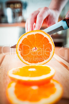 Woman's hands cutting orange