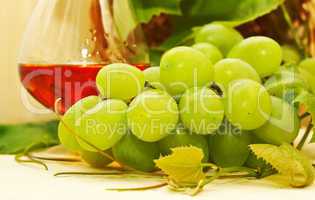 Bunch of white grapes in a basket and a glass of wine