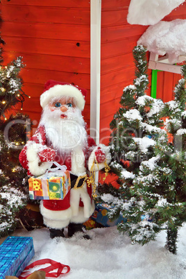 Santa Claus with gifts near the Christmas Tree