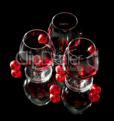 Glasses of wine and chocolate on a black background