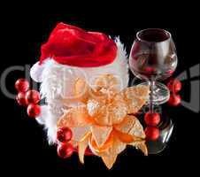 Glasses of wine, tangerine and chocolate and Santa Claus hat on a black background
