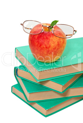 stack of books with an apple and glasses on a white background