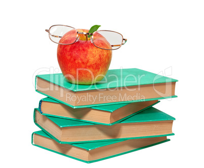 stack of books with an apple and glasses on a white background