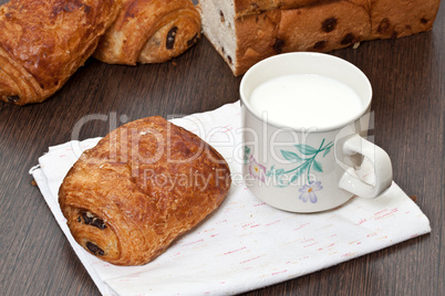 Milk cup and a piece of cake on a wooden table